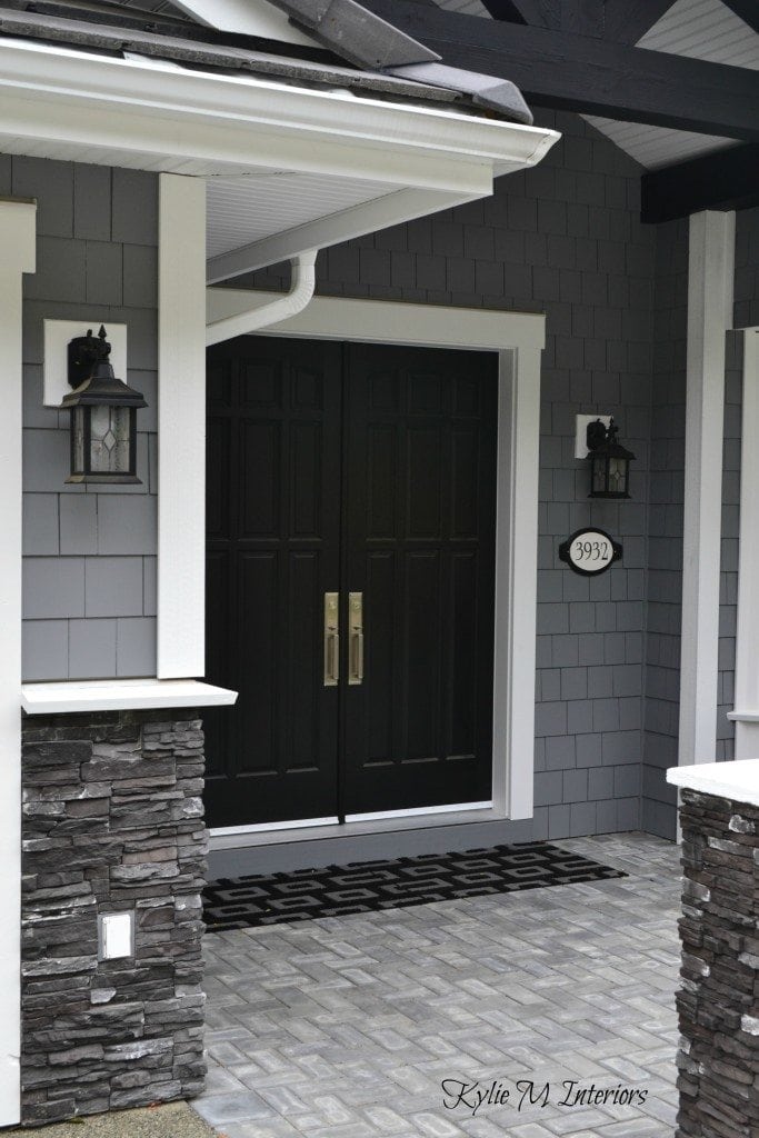exterior of home with chelsea gray painted shakes, black painted double front door and white trim with dark charcoal ledgestone