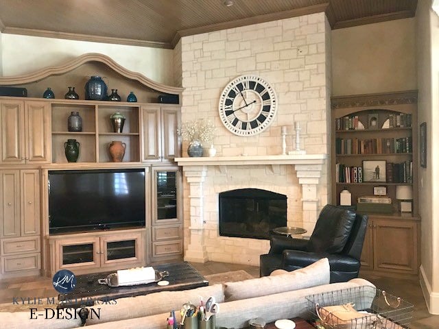 Limestone fireplace with wood ceiling and built-ins. Clock above mantel. Kylie M Interiors before photo, client photo