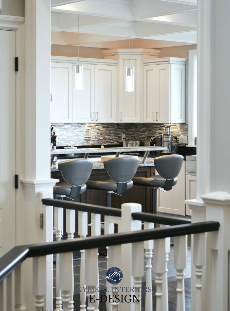 White kitchen, gray stool, black handrail on white stairs. Kylie M E-design, online decorating, virtual packages. Update ideas for 2000s staircase, is it good to paint railing black?