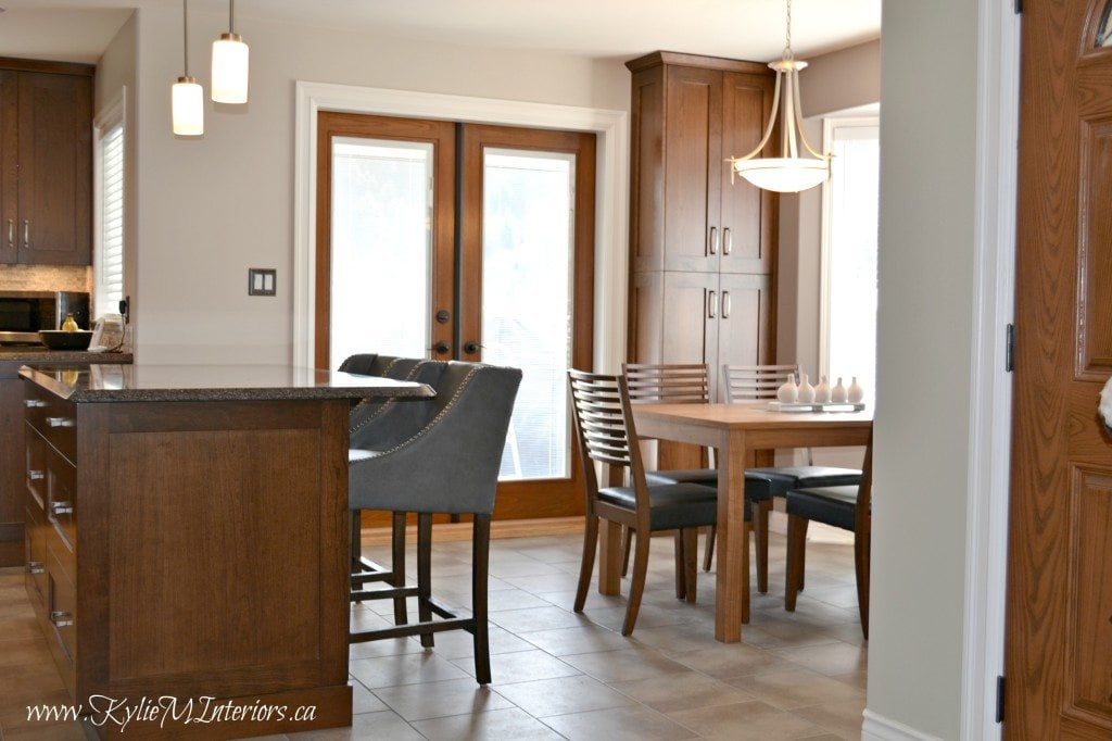 open layout kitchen and dining room with island, quartz countertops and benjamin moore abalone and sandlot gray with purple travertine backsplash