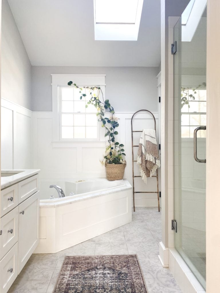 Sherwin Williams On the Rocks, HIgh Reflective White bathroom, corner bathtub, white vanity, marble look quartz counterto, wainscoting, Kylie M Interiors, Jenna Christian