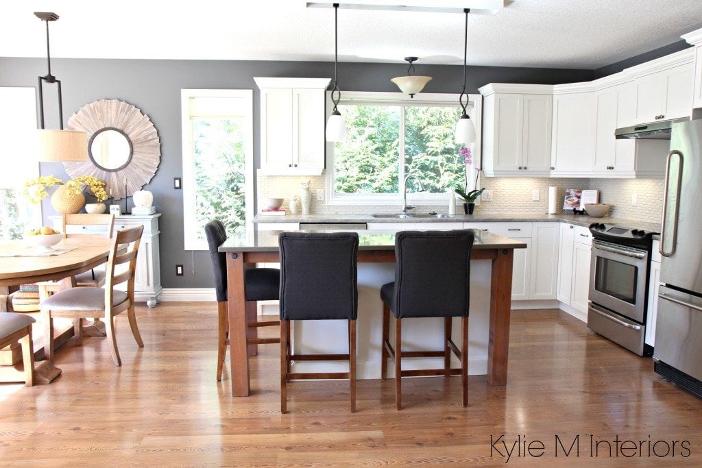 Open layout kitchen and dining, subtle country farmhouse style. Maple cabinets painted Cloud White, gray quartz, soapstone formica and rustic wood supports with stainless steel