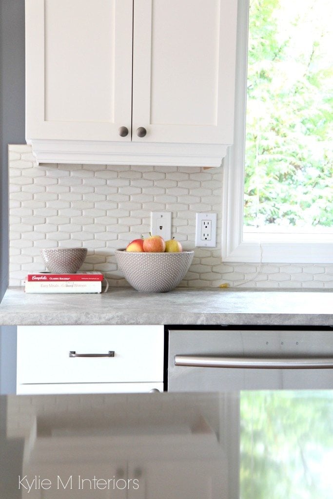 Shaker maple cabinets painted Cloud White with gray and greige quartz and soapstone look countertops. Hexagon backsplash tile in cream