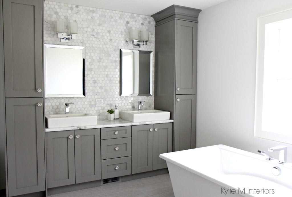 Double vanity with storage towers painted Chelsea Gray, free standing tub, marble mosaic tile backsplash and Formica marble laminate countertop by Kylie M Interiors E-Design