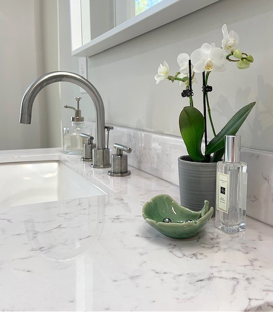 White and gray quartz countertop in small bathrom, green accents, Balboa Mist paint colour on wall. Client photo, Kylie M Interiors Edesign,
