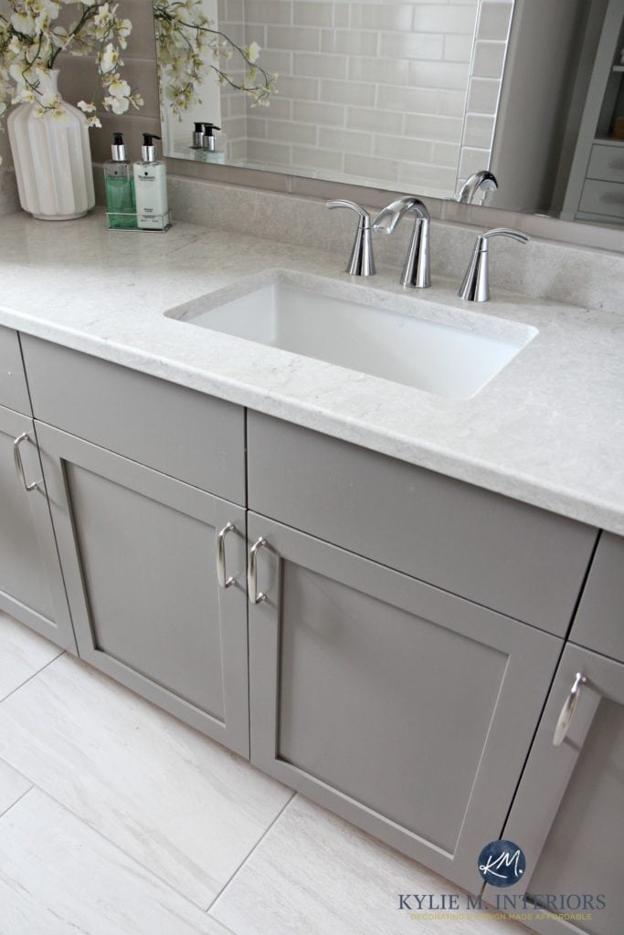Bathroom vanity painted Metropolis Benjamin Moore gray. Caesarstone Bianco Drift greige quartz countertop, Moen Glyde faucet and porcelain tile flooring by Kylie M Interiors