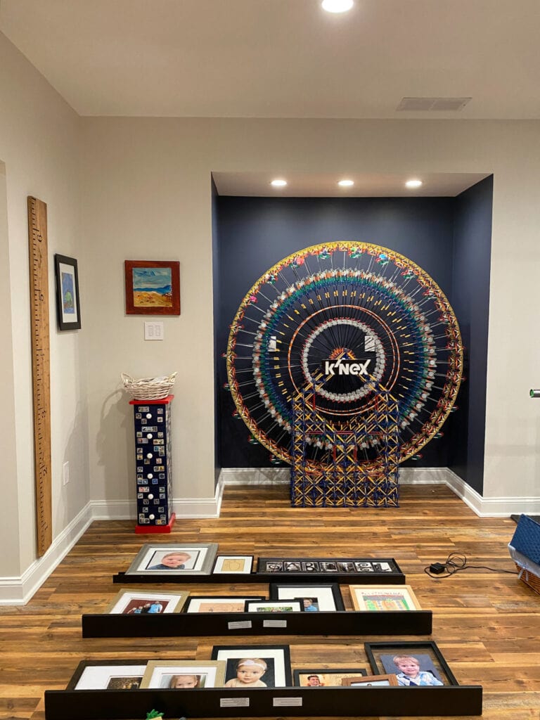 Sherwin Williams Charcoal Blue accent wall, Aesthetic White light beige on walls in basement, dark family room with LVP floor