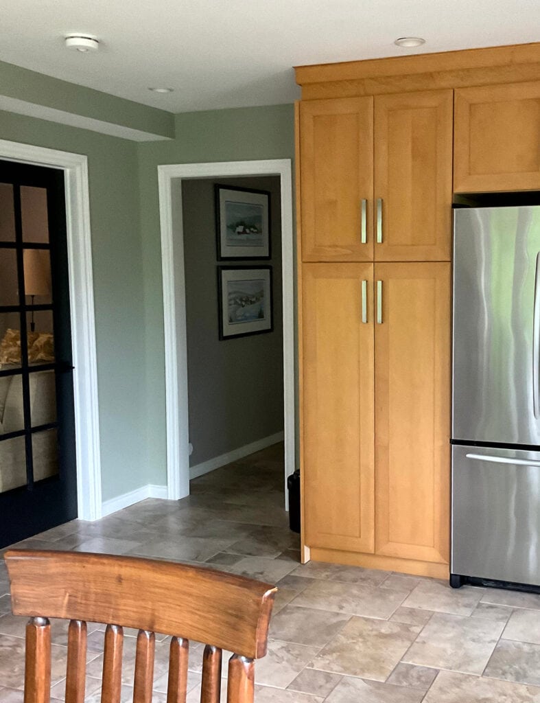 benjamin Moore October Mist, White Dove trim, orange toned maple wood cabinets, beige and warm gray taupe tile floor