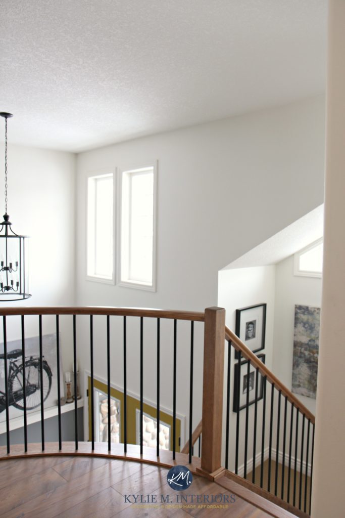 2 storey entryway, foyer and stairwell with rounded or curved wood and metal railing. Sherwin Williams Creamy