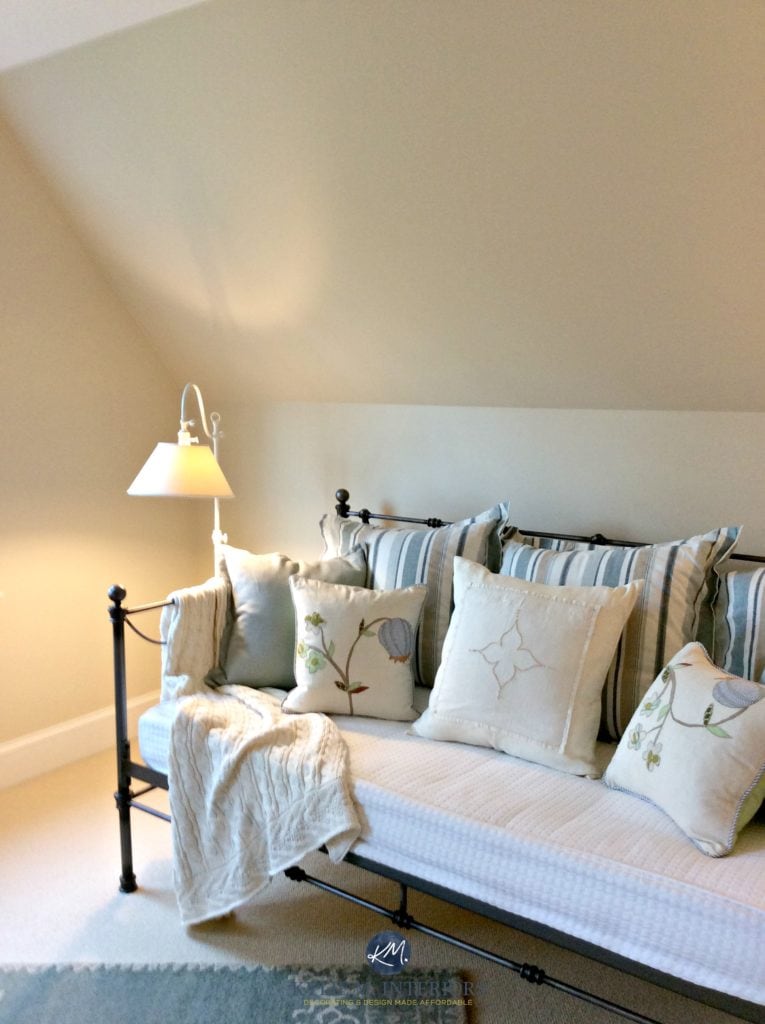 Benjamin Moore Gentle Cream in a guest bedroom wtih sloped ceilings and a day bed with blue accents. Kylie M Interiors E-design and Online Colour Consulting services. Expert color advice