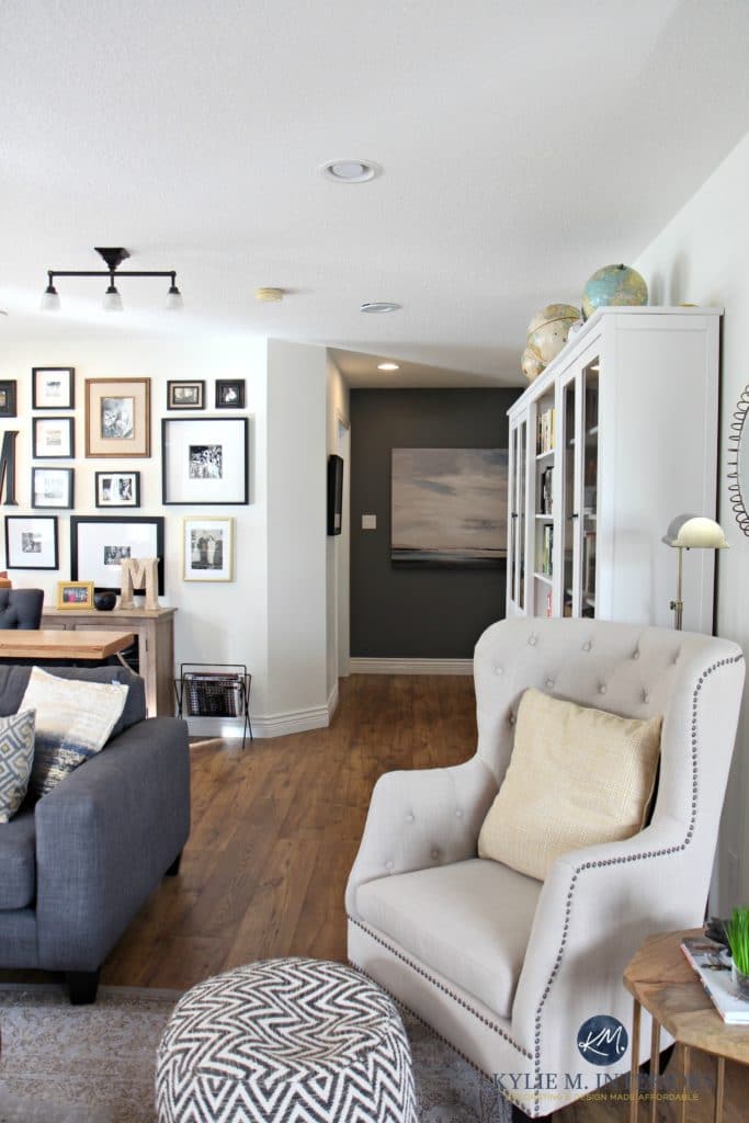 Family room with photo gallery wall, gray sectional. Sherwin Williams Creamy and Benjamin Gray feature wall. Hemnes bookcases and accent chair. Kylie M Interiors