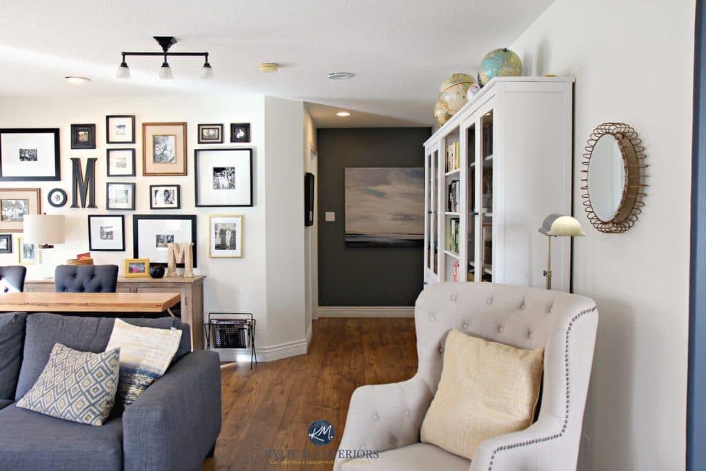 Family room with photo gallery wall, gray sectional. Sherwin Williams Creamy and Benjamin Gray feature wall. Hemnes bookcases. Kylie M Interiors