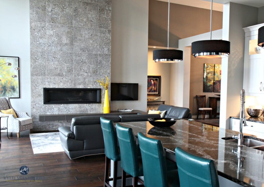 Contemporary open layout kitchen, living room, dining room. Modern tile fireplace dark wood floors. Gray painted walls Cambria Quartz countertop. Kylie M Interiors Decorating and Design Online