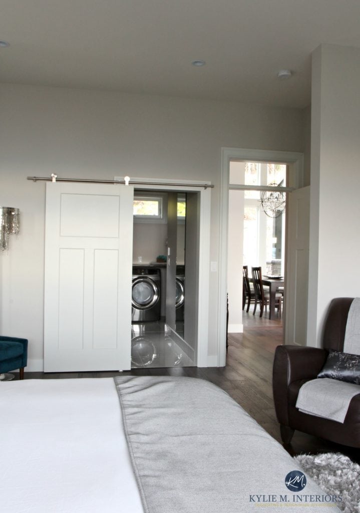 Master bedroom with laundry room in walk in closet with sliding bar door. Paint colour Benjamin Moore Collingwood. Kylie M interiors decorating and design online