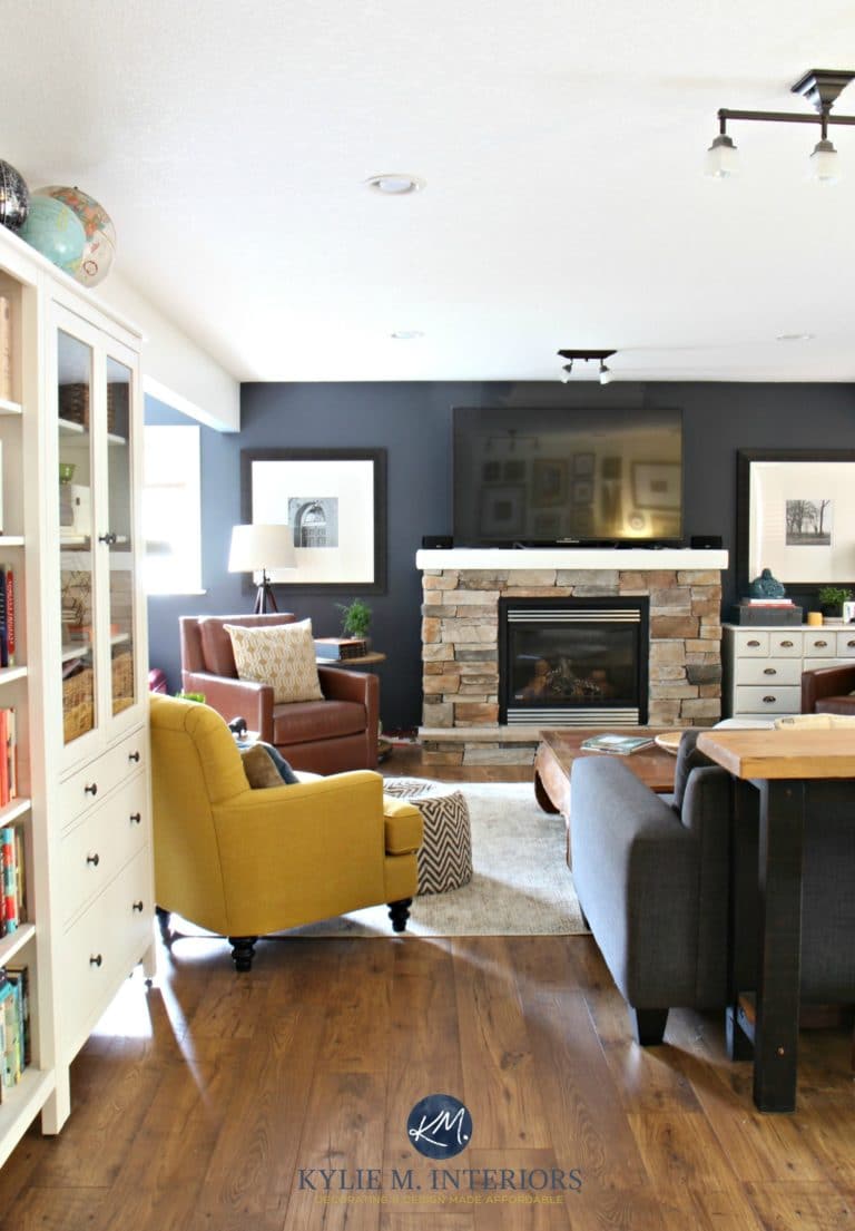 Family room with stone fireplace, Sherwin Williams Cyberspace, leather, laminate wood flooring, chartreuse chair. Kylie M INteriors E-design and home