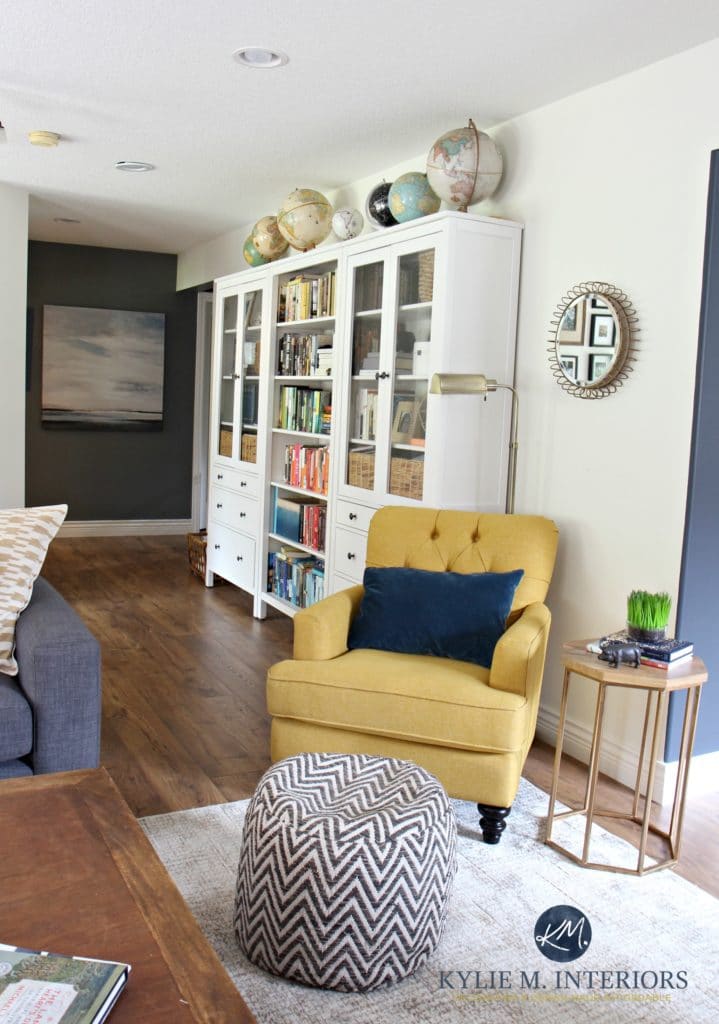 Ikea Hemnes bookcases in family room with chartreuse accent chair. Sherwin Williams Creamy paint color and home decor. Globe collection. Kylie M Interiors E-design