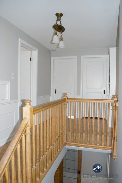 Sherwin Williams Big Chill in hallway and stairwell wtih white wainscoting, doors and trim. Oak floor and handrail. Kylie M INteriors, e-decor, e-design