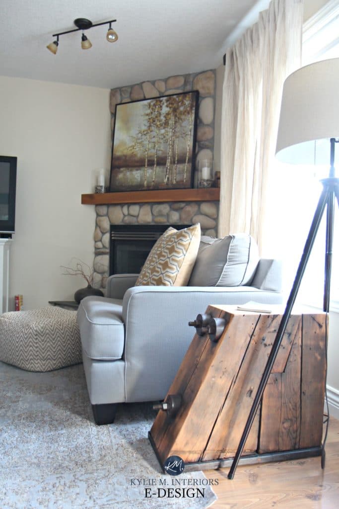 Living room with south west facing exposure and rock fireplace with mantle. Benjamin Moore Gentle Cream. Kylie M E-design
