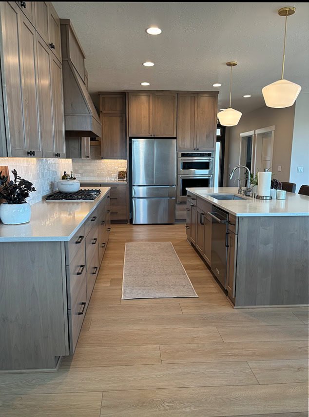 Wood ashy tone stained kitchen cabines and quartz countertop, wood floor, Agreeable Gray walls, Sandstone quartz perimeter, Enigma on the island, pendants
