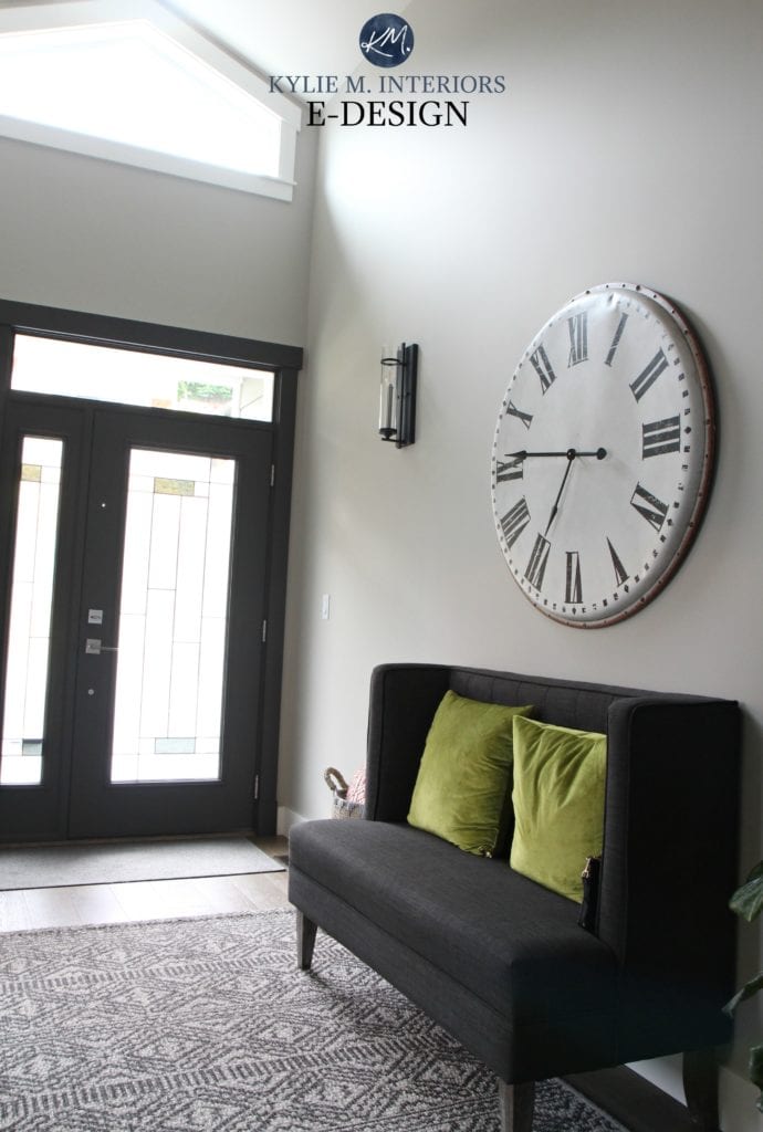 Entryway with Sherwin Williams Collonade Gray, front door painted Urbane Bronze, Pier 1 rug, large oversize metal clock and gray bench. Kylie M Interiors Edesign and online paint color consulting