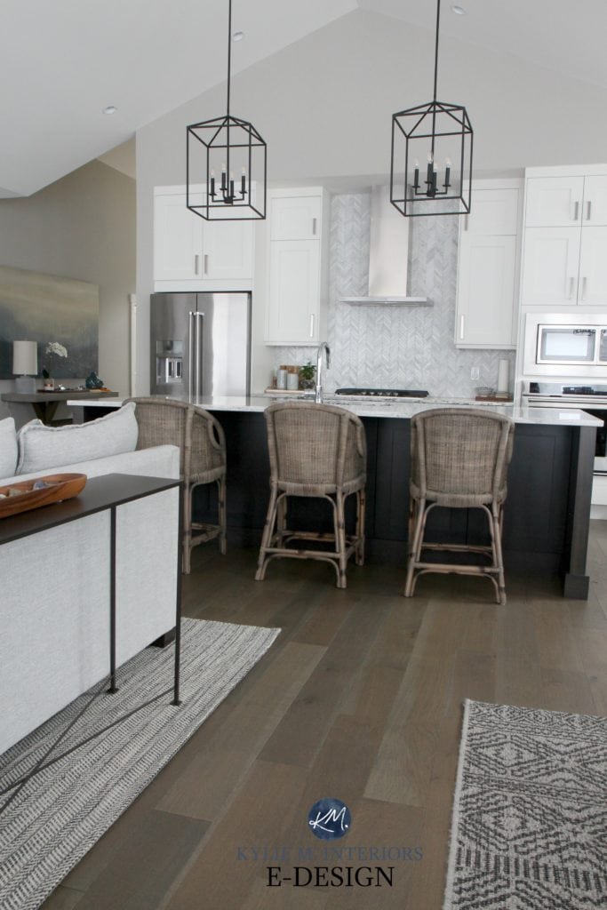 Open layout kitchen, Sherwin Williams Alabaster kitchen with marble herringbone backsplash and black pendant lighting over island. Rattan bar stools and textured area rugs. Kylie M Interiors