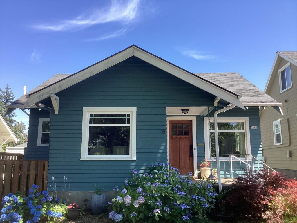 Sherwin Williams Mediterranean exterior blue paint color on siding, Craftsman small home, Snowbound trim and wood front door.