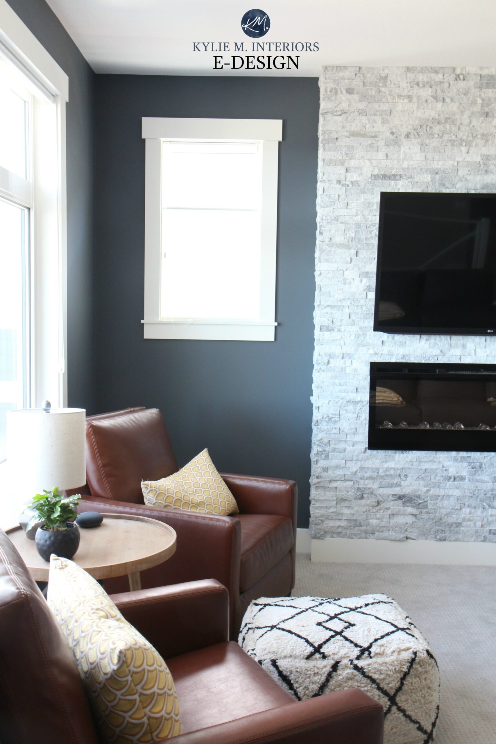 Benjamin Moore Anchor Gray, White Dove trim, travertine stacked stone fireplace, tobacco brown leather chairs, gray carpet. Kylie M Interiors E-design, online paint color consulting. Best blue paint