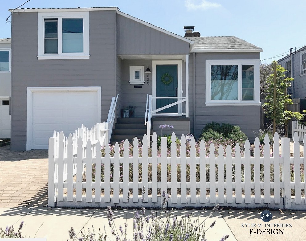 Exterior painted gray with purple undertone, blue green front door, Folkestone stairs, white picket fence and white trim and garage. Sherwin Williams Still Water, Polished Concrete siding, Pure White trim Kylie M Interiors Edesign, online paint colour consultation.