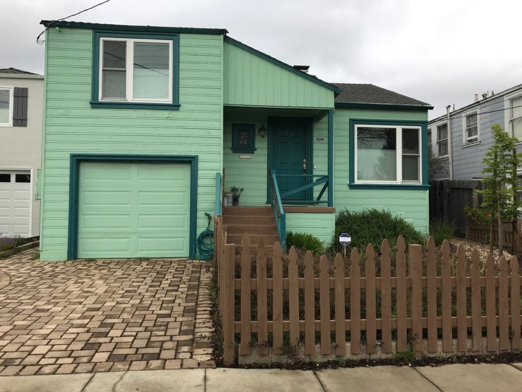 Exterior that is green and teal and not good before being painted