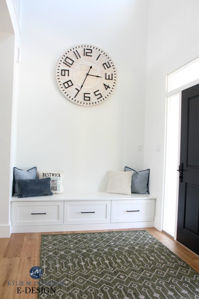 Kylie M Interiors EDESIGN. Entryway with vaulted ceiling, large oversized wall clock, builtin bench, painted black front door, Sherwin Williams Pure White walls, trim. Online paint colour advice blog