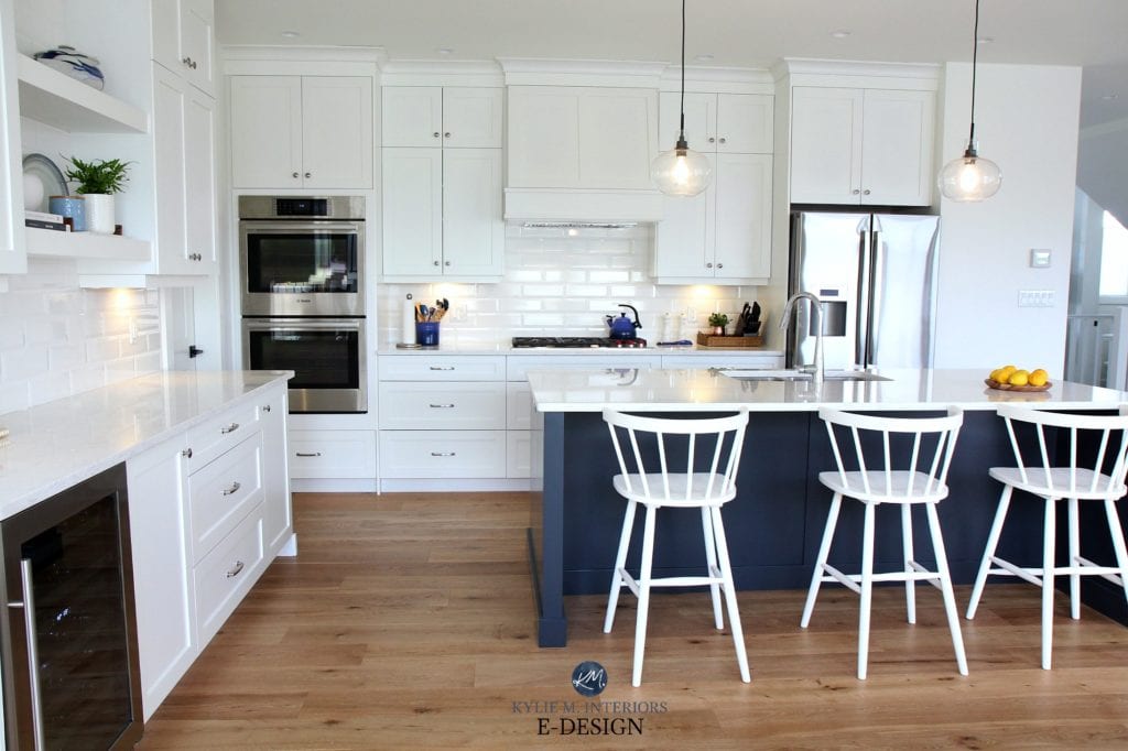Kylie M Interiors Edesign, online paint colour expert. White oak flooring, Sherwin Williams Pure White kitchen cabinets, white bevelled subway tile, navy blue island and white quartz countertops