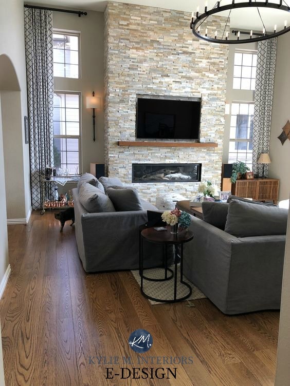 Popular gray or greige paint colour, Sherwin Williams Anew Gray, stacked stone fireplace, vaulted ceiling, oak floors, round chandelier. Kylie M INteriors Edesign, client photo