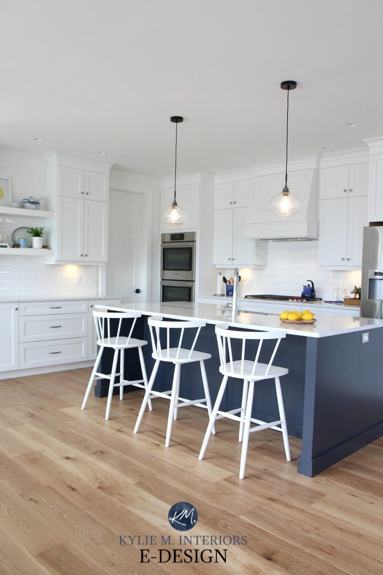 Pure White kitchen cabinets, subway tile backsplash, white quartz and oak flooring. Navy blue island Sherwin Williams Cyberspace, prep bar station.