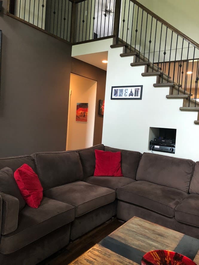 BEFORE REMODEL, living room with open staircase that's dark