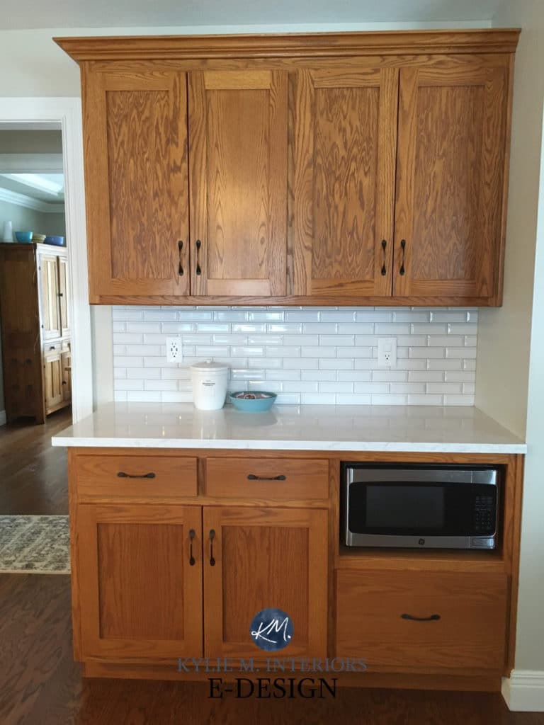 Update oak wood kitchen cabinets with quartz white countertop, subway tile and painted island. Ideas from Kylie M Interiors Edesign, paint color advice blogger