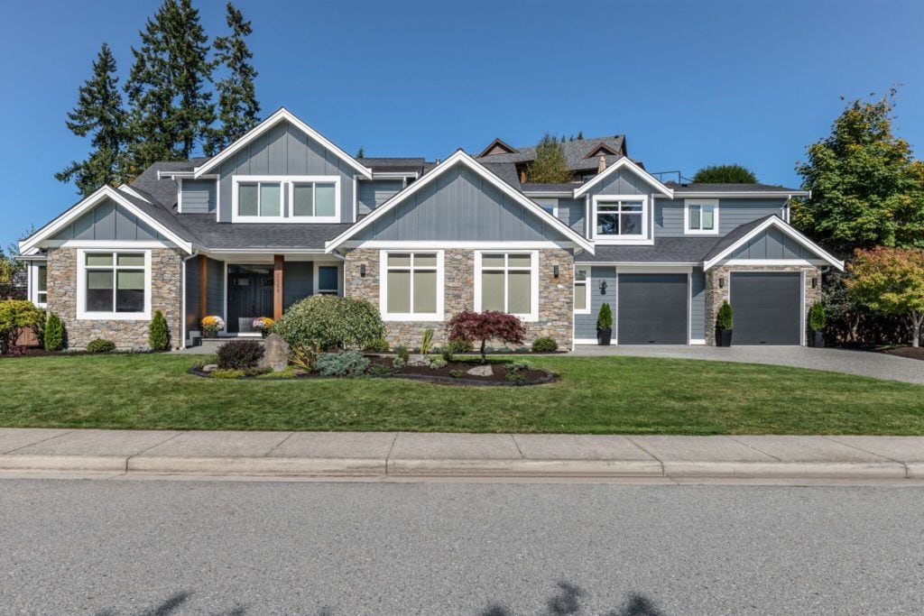 Dark gray exterior siding, hardi, white trim, stone, black garage doors. South facing light. Kylie M Interiors Edesign, online paint colour consulting