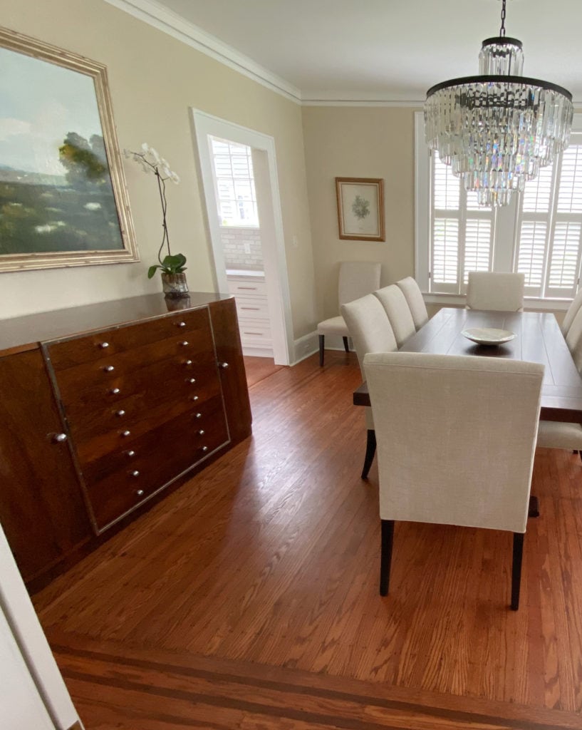 Dining room in lightened Benjamin Moore Shaker Beige, orange-red toned wood flooring. Client photo before Kylie M Interiors Edesign