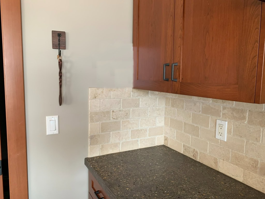 Sherwin Williams Amazing Gray, cherry red orange stained kitchen cabinets, travertine tile backsplash, black granite countertop. greige paint color