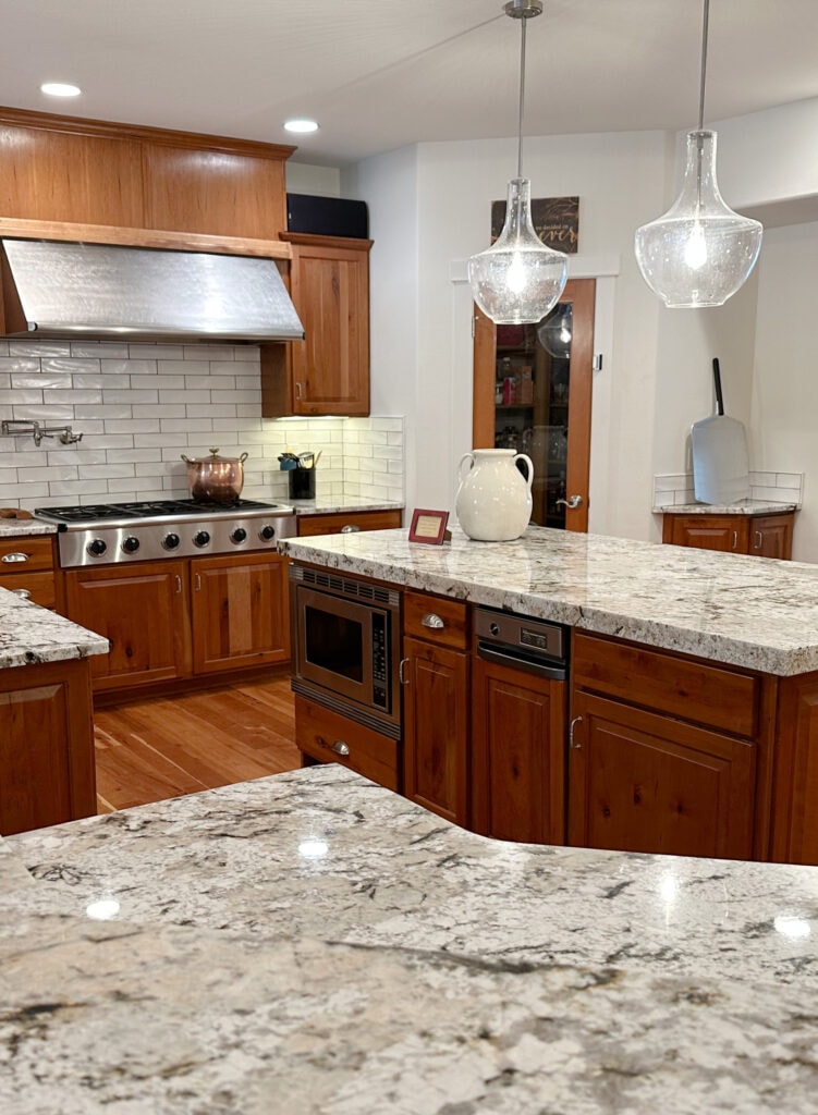 Kitchen with wood fir or cherry red orange stain cabinets with wood floor. Granite countertops, off-white subway tile backsplash, Creamy walls, Alabaster trim. update ideas for wood