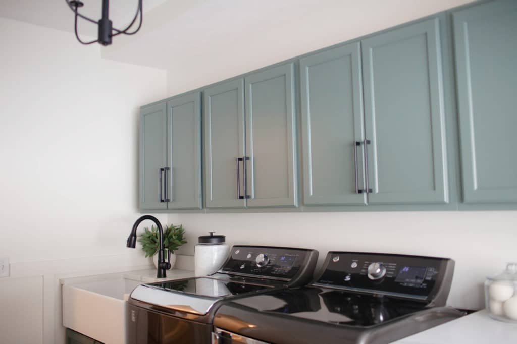DIY laundry room update. Cabinets painted Benjamin Moore Caldwell Green, walls White Dove. Dark gray washer and dryer. Kylie M Interiors Online paint colour diy decorating consultant and ideas