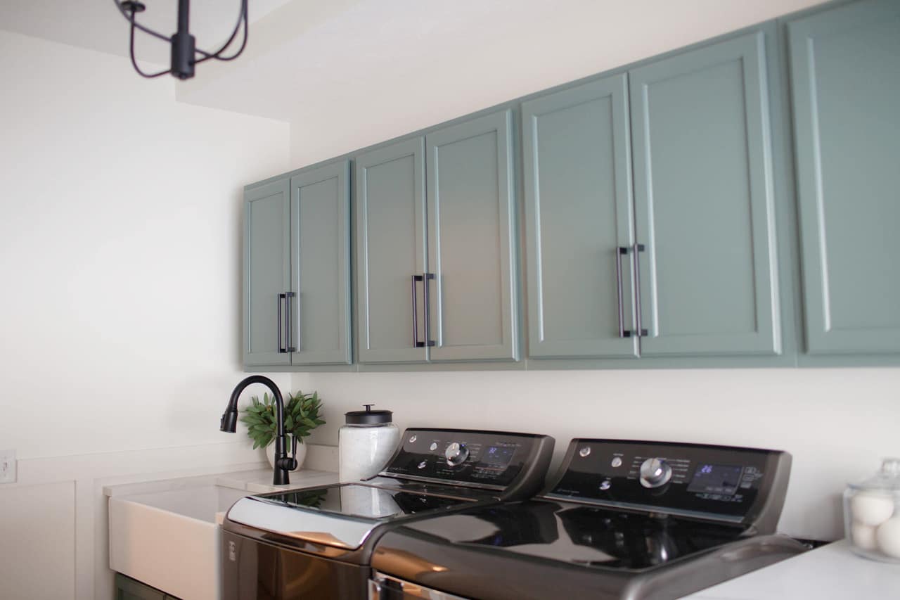 DIY laundry room update. Cabinets painted Benjamin Moore Caldwell Green, walls White Dove. Dark gray washer and dryer. Kylie M Interiors Online paint colour diy decorating consultant and ideas