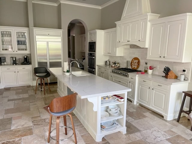 Sherwin Williams best greige Amazing Gray walls, Alabaster warm white painted cabinets, travertine tile floor, white quartz Calcatta Valentin. Kylie M Color consulting client