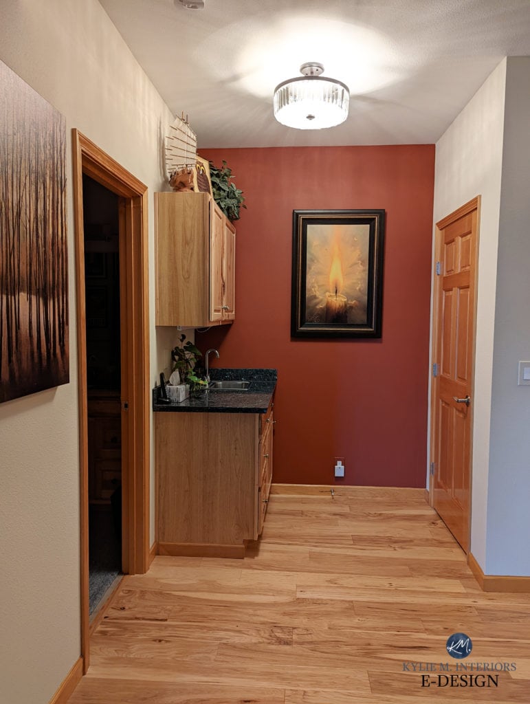 BEnjamin Moore Navajo White with feature or accent wall paint colour in Sherwin Williams Roycroft Copper Red, wood trim, wood floor and door.