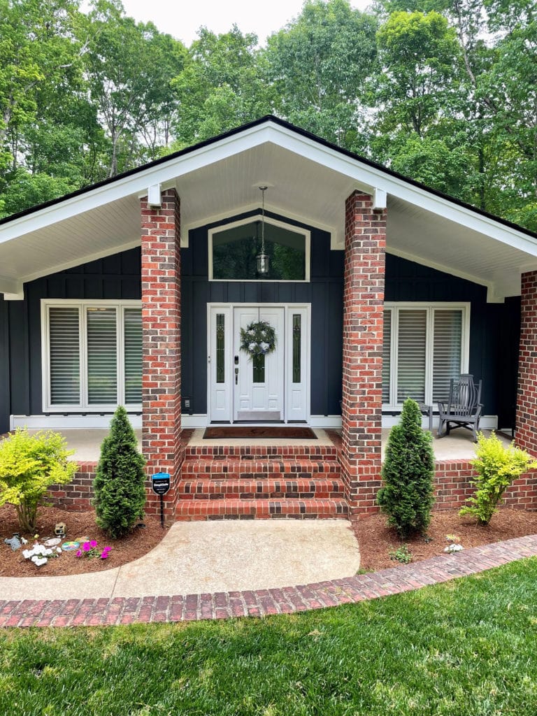 Red orange brick exterior, mid century modern style home, Sherwin Extra White trim and white front door, Hardie Iron Gray siding.