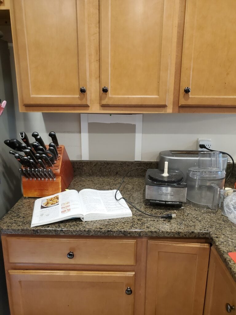 Sherwin Williams Anew Gray with speckled brown greige granite countertop and old maple cabinets