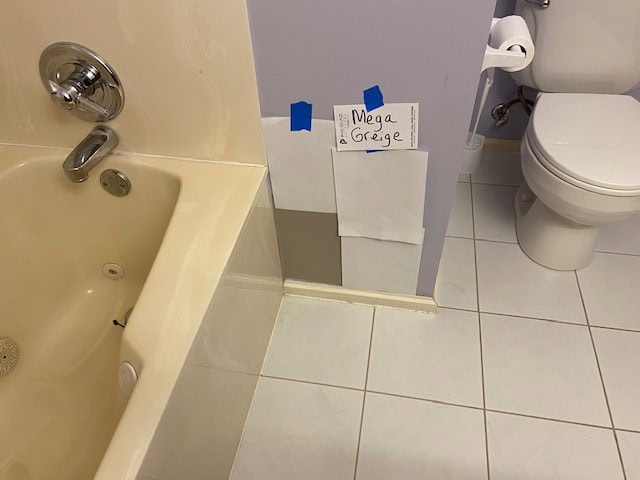 Sherwin Williams Mega Greige with almond cream bone tub and tan greige tan tile floor in bathroom