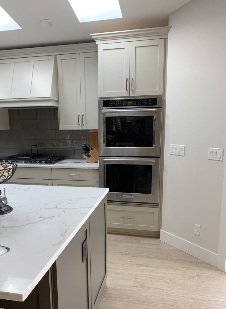 Kitchen cabinets painted Benjamin Moore Revere Pewter, walls lightened Edgecomb Gray, white quartz countertop. Kylie M Interiors Edesign, diy update ideas, wood floor