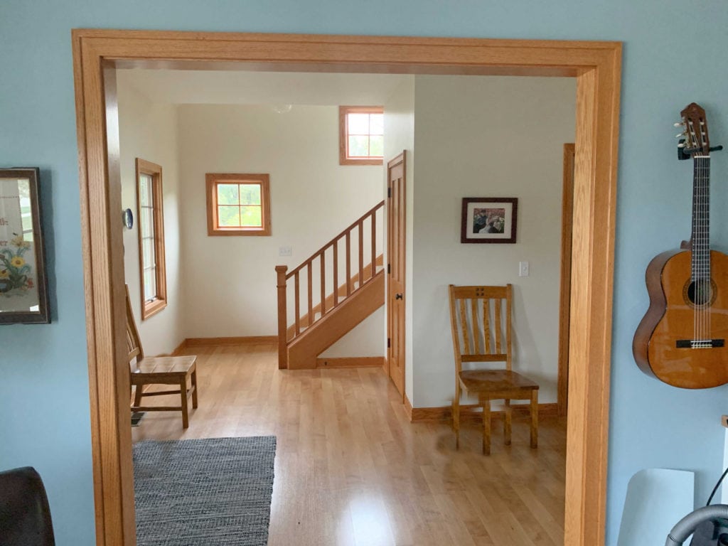Sherwin Williams Neutral Ground with orange toned wood trim, stairs and flooring. Best warm neutral paint colors. Kylie M Interiors Edesign