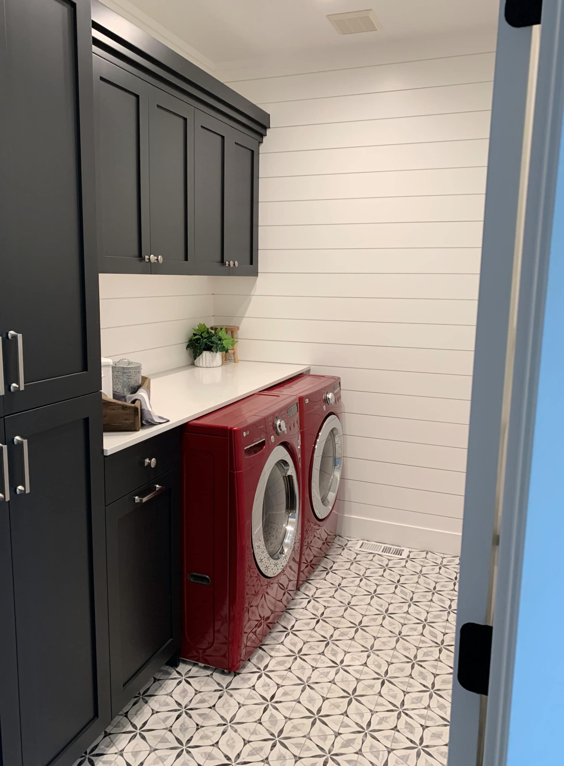 Sherwin Williams Tricorn Black and High Reflective White in laundry room, pattern tile floor, red washer and dryer. CLIENT PHOTO of Kylie M Interiors Edesign