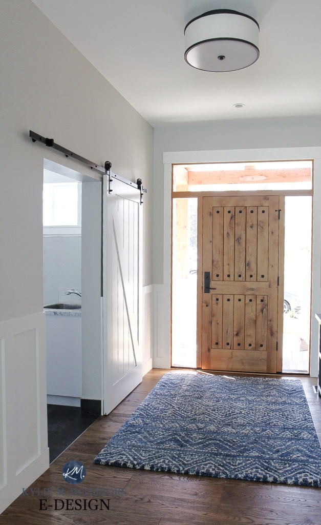 Solid wood custom front door, Benjamin Moore Stonington Gray paint color on walls, oak floor, High Reflective White (Sherwin) trim and board and batten in foyer entryway. Kylie M Interiors Edesign